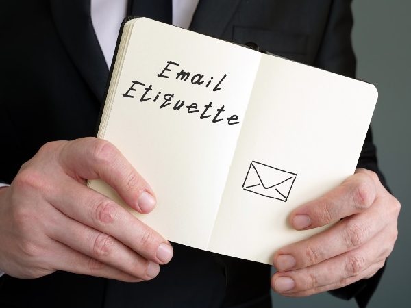 man with a notebook showing the words Email Etiquette
