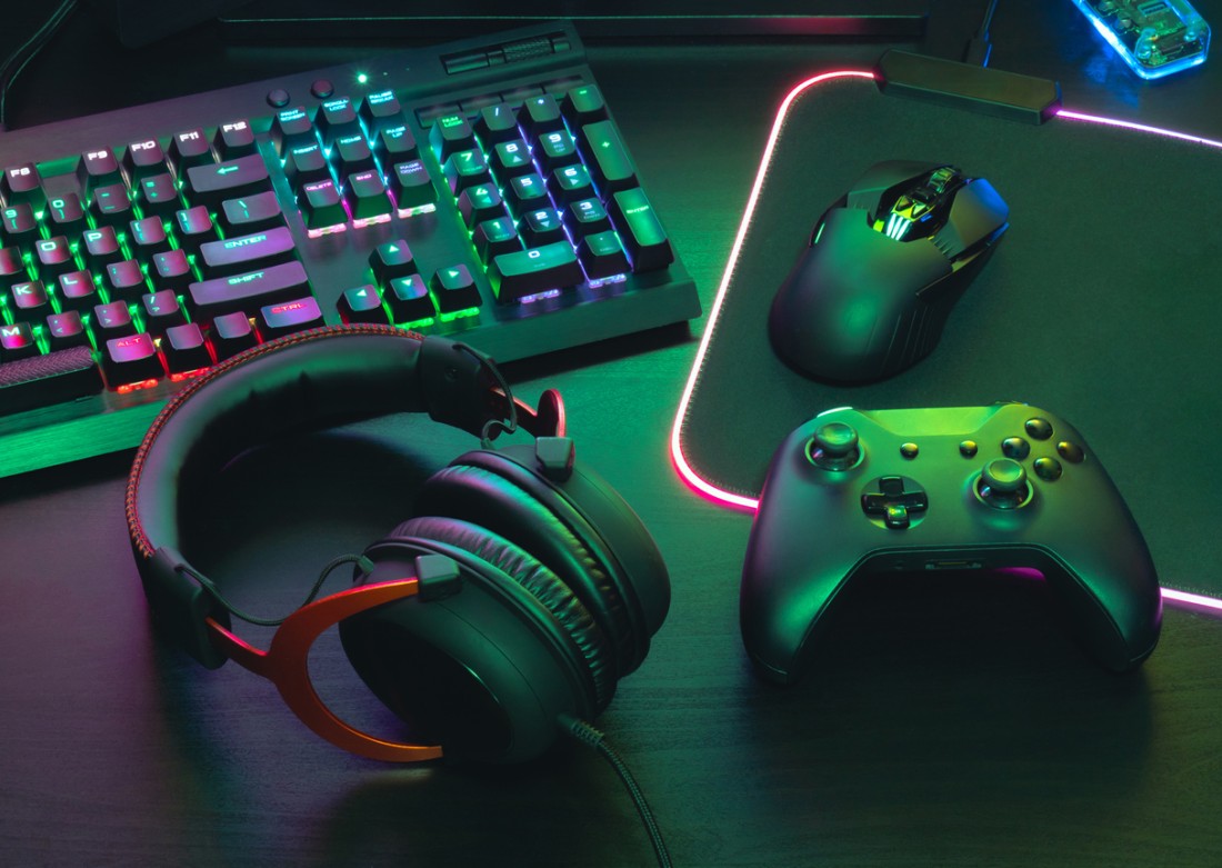 table with a keyboard, headset, game controller and mouse