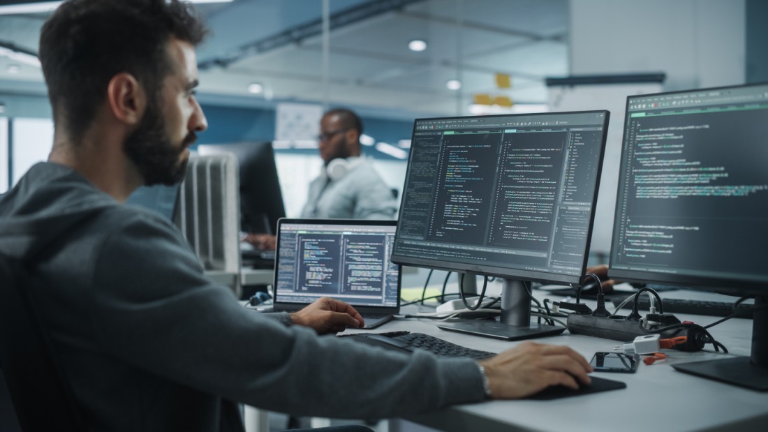 man working in Data Analytics using two computers