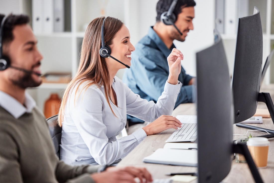 Telemarketing team working with earphones and computers