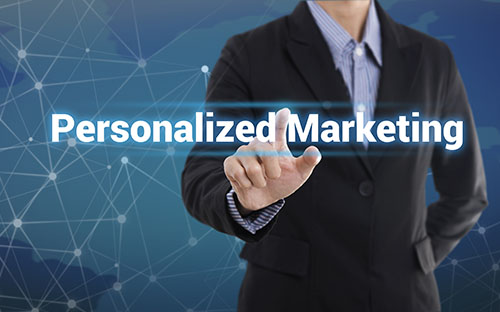 A man in a suit reaches toward an overlay of the words written Personalized Marketing