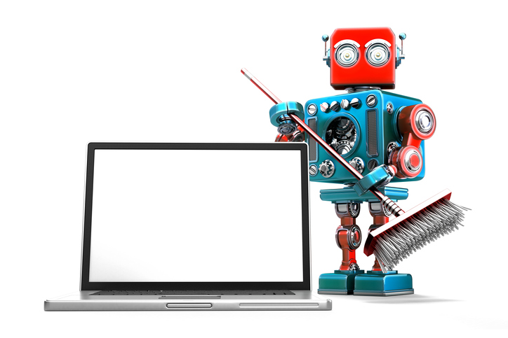 A robot stands next to a laptop with a broom in its hands. Cleaning data is important for your business.